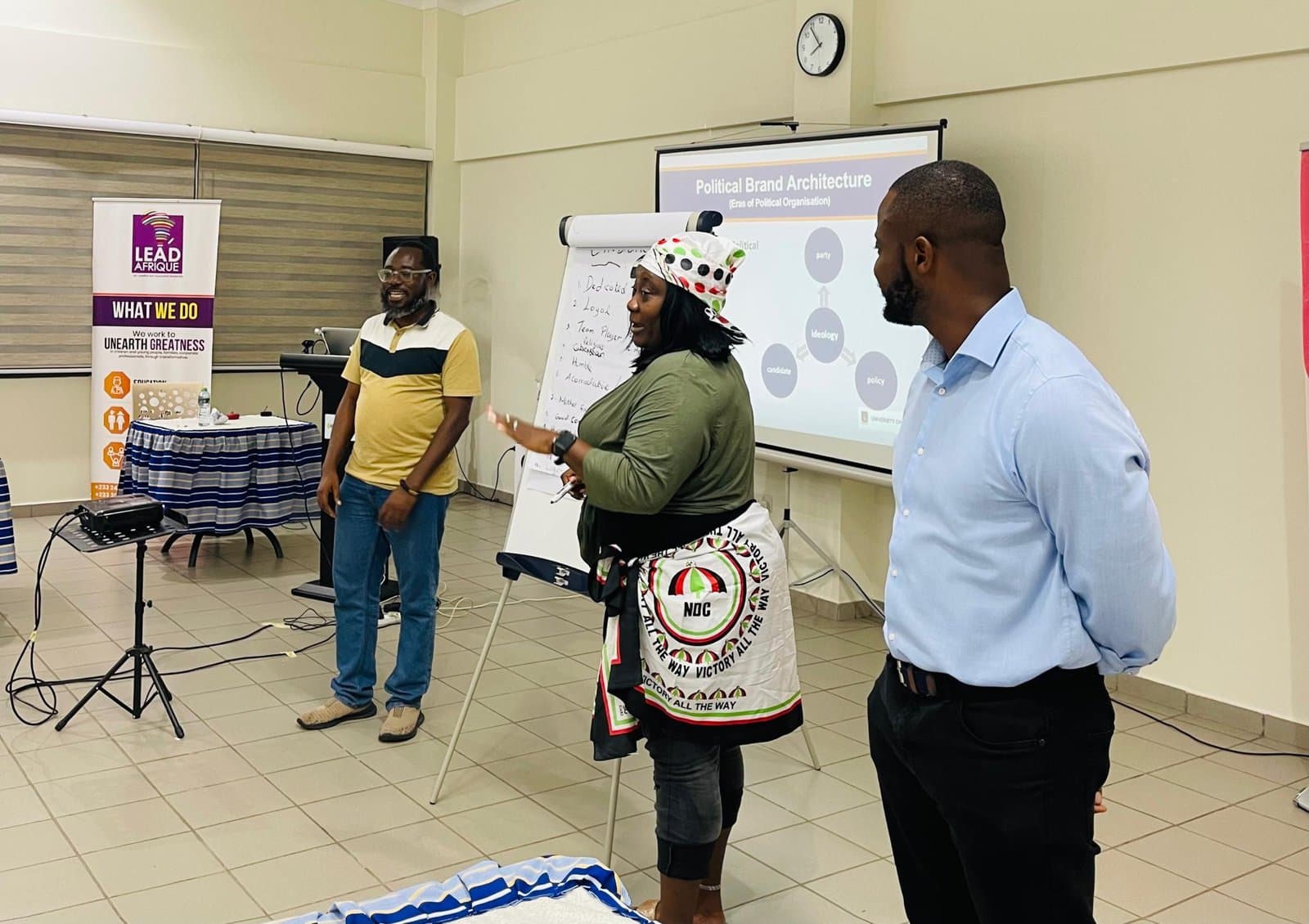 Prof. Kobby Mensah and a panellist speaking at an Empowering Women in Politics (EWiP) workshop, with a slide on Political Brand Architecture in the background